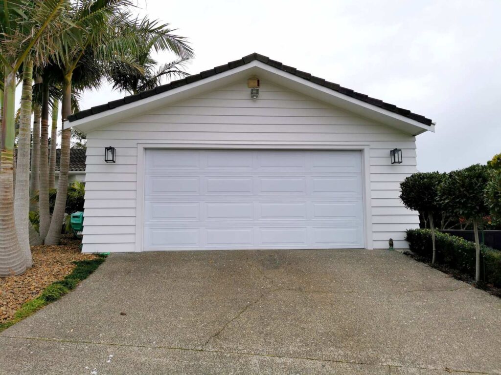 White double garage door on a detached garage with concrete driveway